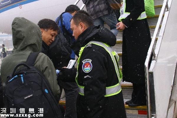 圖：監(jiān)護(hù)員認(rèn)真查驗(yàn)登機(jī)牌